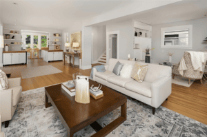 Bright and spacious living room with white walls and hardwood floors.